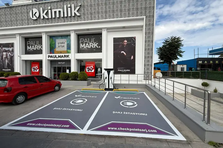 Paulmark mağazasının önünde iki şarj yeri ve DC şarj ünitesi